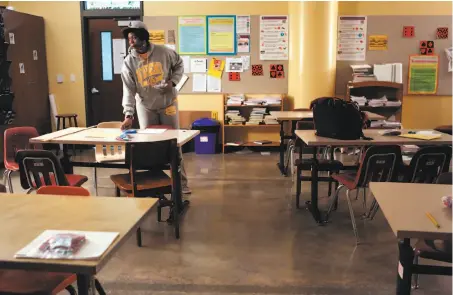  ?? Photos by Amy Osborne / Special to The Chronicle ?? Etoria Cheeks cleans up her classroom after coaching a badminton match at the high school where she teaches math.