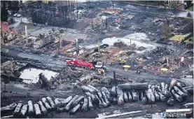  ??  ?? Workers comb through debris in Lac-Mégantic, Que., after the July 9, 2013, explosion of railway cars carrying crude oil.