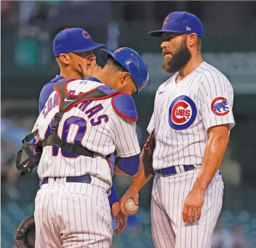  ?? NUCCIO DINUZZO/GETTY IMAGES ?? Pitching coach Tommy Hottovy (rear) visits Jake Arrieta on the mound Wednesday during what turned out to be his final start as a Cub.
