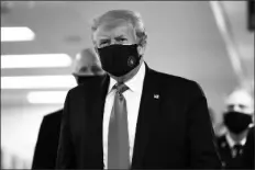  ?? ASSOCIATED PRESS ?? PRESIDENT DONALD TRUMP wears a mask as he walks down the hallway during his visit to Walter Reed National Military Medical Center in Bethesda, Md., on Saturday.