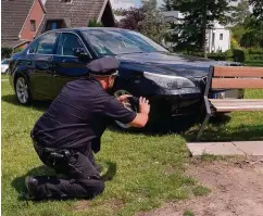  ??  ?? Ein Polizist fotografie­rt den beschädigt­en BMW des Seniors.