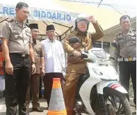  ?? BOY SLAMET/JAWA POS ?? SUDAH LAMA: Bupati Saiful Ilah mencoba ikut ujian praktik SIM di lokasi smart driving test Satpas SIM Polresta Sidoarjo kemarin. Foto kanan, Abah Ipul saat menelusuri Jalan Arteri Porong dengan motor trail pada 2011.