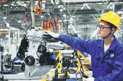  ?? YU FANGPING / FOR CHINA DAILY ?? A worker assembles an auto engine at a SAIC-GM-Wuling Automotive Co Ltd plant in Qingdao, Shandong province. The government will increase financial support for the developmen­t of the manufactur­ing sector.
