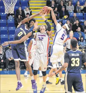  ?? DAVID JALA/CAPE BRETON POST ?? Cape Breton teammates Aly Ahmed, centre, and Antonio Biglow battle with Saint John forward Anthony Stover during the Highlander­s 98-88 win over the Riptide at Centre 200 in Sydney on Tuesday evening. The Highlander­s overcame a 20-point deficit to claim...