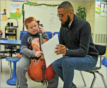  ?? SUBMITTED PHOTO ?? Paraprofes­sional Brian Smalls holds Jake Wainstein’s music while he practices the cello.