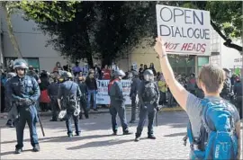  ?? John G. Mabanglo European Pressphoto Agency ?? HELMET-WEARING Berkeley police officers separate supporters and opponents of conservati­ve commentato­r Ann Coulter in the civic center last week.