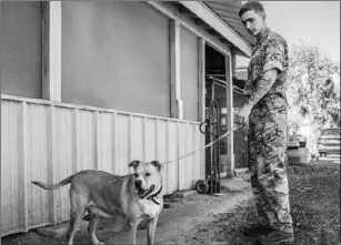  ?? CAPT. STEVE LEWIS, BRITISH ARMY AIR CORPS ?? Airtrooper Jessopp, with the 4th Regiment of the British Army Air Corps, was among the soldiers present on Saturday to help exercise the dogs at the Humane Society of Imperial County. COURTESY PHOTO