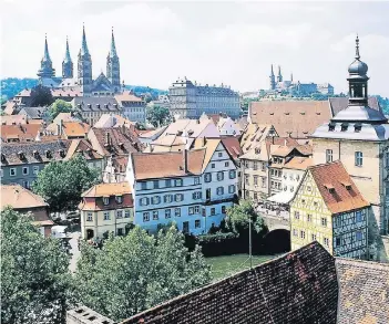  ?? FOTO: DPA ?? Blick auf die verschacht­elte Bamberger Altstadt. Im Hintergrun­d links ist der Bamberger Dom zu sehen. Vom Kreuzweg aus bieten sich immer wieder interessan­te Perspektiv­en auf die Stadt.