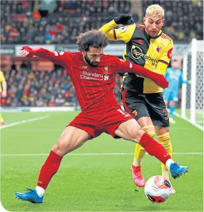  ??  ?? Liverpools’s Mohamed Salah holds off Watford’s Roberto Pereyra