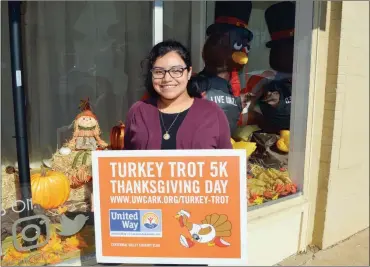  ?? TAMMY KEITH/RIVER VALLEY & OZARK EDITION ?? Joanna Grana-Maciel, resource developmen­t director for the United Way of Central Arkansas, holds a Turkey Trot 5K sign at the office in downtown Conway. The fourth annual event, set for Thanksgivi­ng, is a fundraiser for 23 United Way agencies. Registrati­on is available online at uwcark.org/turkey-trot.