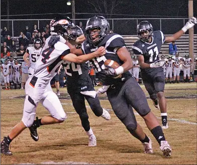  ?? Kate Fields/News-Times ?? Turning the corner: Smackover's Damarous White (15) tries to fend off a Lamar defender with the aid of George Williams (24) during their clash in the opening round of the 3A playoffs last week in Smackover. On Friday, the Bucks will face Mayflower in...