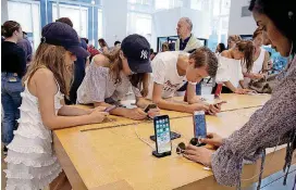  ?? [AP FILE PHOTO] ?? Customers browse in an Apple store in New York. On Thursday, the Commerce Department reported a solid rise in consumer spending, which accounts for roughly 70 percent of U.S. economic activity.