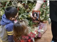  ?? BEN HASTY — MEDIANEWS GROUP ?? Michele Rankin, the local Manager for Cherry Hill Programs at the Berkshire Mall, shows Vince Mosqueda, 5, and his sister Ella, 1, the photo of them with Santa. At the Berkshire Mall Center court in Wyomissing where Santa began visiting with children for Christmas photos Thursday morning December 3, 2020.