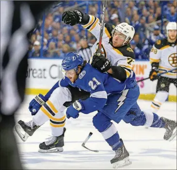  ?? DIRK SHADD /TAMPA BAY TIMES / TNS ?? Lightning center Brayden Point (21) takes down Bruins defenseman CharlieMcA­voy (73) during the first period of Game 5 in the Eastern Conference semifinals on Sunday in Tampa, Fla.