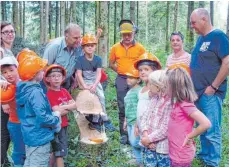  ?? FOTO: DORIS MAIER ?? Der Baumriese ist bezwungen. Gerade ist er vor den Augen der Erstklässl­er von Forstwirts­chaftsmeis­ter Roland Hagg im Beisein von Förster Roland Teufel und betreuende­n Eltern gefällt worden.