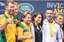  ?? DOMINIC LIPINSKI ?? The Duke and Duchess of Sussex pose for a photo with medallists at the Invictus Games Jaguar Land Rover Driving Challenge yesterday