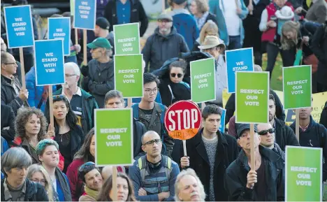  ?? GERRY KAHRMANN ?? Noah Benson holds a stop sign at a rally in support of fired Vancouver School Board trustees outside the VSB offices on Thursday.