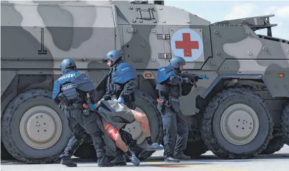 ?? FOTO: AFP ?? Trainieren für den Ernstfall: Eine Sondereinh­eit der Polizei kümmert sich um einen Verletzten.