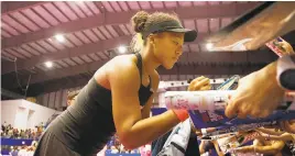  ?? KOJI WATANABE/GETTY IMAGES ?? Naomi Osaka of Japan signs autographs for fans after her victory against Dominika Cibulkova of Slovakia on day three of the Toray Pan Pacific Open at Arena Tachikawa Tachihi on Wednesday, in Tokyo, Japan.