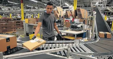  ?? /AFP ?? Package deal: An Amazon worker sorts packages onto a conveyor belt at an Amazon fulfilment centre in Tracy, California. The company says it has settled a major tax claim in France amid a tax crackdown by EU countries.