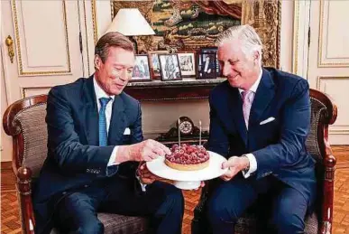  ?? Foto: Belgian Royal Palace, Bas Bogaerts ?? Großherzog Henri (l.) und König Philippe teilen sich einen Geburtstag­skuchen.