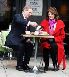  ??  ?? AWKWARD: Taoiseach Enda Kenny pours the tea for Tanaiste and Labour leader Joan Burton outside a cafe in Dublin