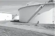  ?? [PHOTO BY PAUL HELLSTERN, THE OKLAHOMAN ARCHIVES] ?? BlueKnight Energy’s Facility manager Jerry Fore checks out an oil storage tank near its capacity at the company’s storage hub in Cushing.