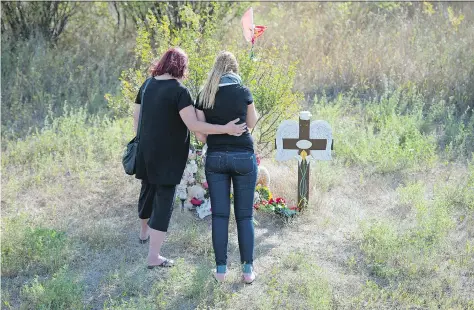  ?? TROY FLEECE ?? Marion Haluik, left, joins her granddaugh­ter Dakota Schmidt at a roadside memorial in August at the site of a crash, approximat­ely 40 kilometres north of Regina on Highway 6, where Dakota’s mother, Daphne, was killed by an impaired driver. Dakota was...