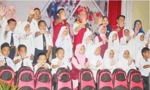  ??  ?? HAJIJI (tengah, barisan belakang) serta para murid yang menerima bantuan menunjukka­n tanda TN50. Turut kelihatan, Tah Nia, Efaridun dan Jasni.