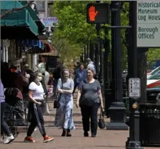  ?? Gene J. Puskar/Associated Press ?? People, some wearing face masks, walk by shops Tuesday in Beaver.