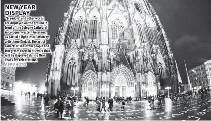  ??  ?? “Freedom” and other words are displayed on the ground in front of the Cologne Cathedral in Cologne, western Germany, as part of a light installati­on by artist Ingo Dietzel. The artist collects wishes from people and integrates them in his work that...