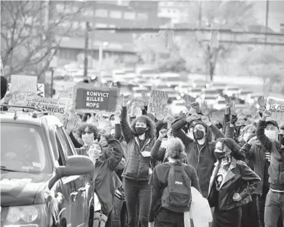  ?? KARL MERTON FERRON/BALTIMORE SUN ?? Protesters walk down President Street as traffic backs up at the end of southbound Jones Falls Expressway. Crowds gathered Friday to march in protest of police violence and the fatal shooting of Daunte Wright in Minnesota.