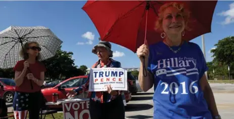  ?? TAIMY ALVAREZ/TNS ?? Competing supporters of Trump and Clinton try to woo voters in Boca Raton, Fla., north of Miami. Florida, a key battlegrou­nd state, was leaning to Trump.
