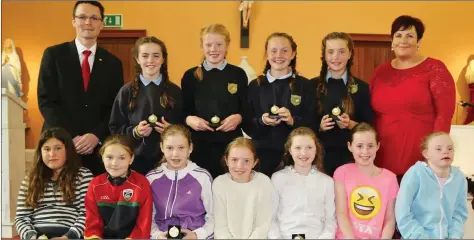  ??  ?? These girls were honoured for their football skills at the Meelin NS end of year celebratio­n, pictured with Patrick O’Donovan, Junior Minister for Tourism and Sport, and Principal Celine Doody. Photo: Sheila Fitzgerald