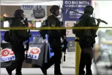  ?? Will Lester/Inland Valley Daily Bulletin/SCNG via AP ?? Heavily armed police officers exit Costco following a shooting inside the wholesale warehouse Friday in Corona, Calif.