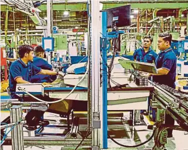  ?? FILE PIC ?? Workers assembling ball bearings at a factory in Nilai. The government is implementi­ng three strategies to ease the people’s burden and assist employees, particular­ly in dealing with difficulti­es due to the Covid-19 pandemic.