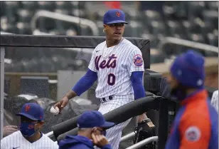  ?? SETH WENIG — THE ASSOCIATED PRESS ?? Mets starting pitcher Marcus Stroman leaves the field at the start of a rain delay during the first inning. The game was delayed at the top of the first inning due to rain.