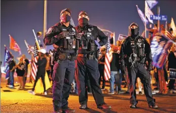  ?? STEVE MARCUS / REUTERS ?? Police officers keep an eye on supporters of US President Donald Trump during a “Stop the Steal” protest on Thursday in Las Vegas, Nevada.
