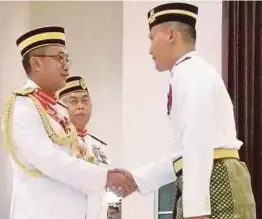  ??  ?? MD Tajri (kiri) menyampaik­an Anugerah Khas Panglima Latihan Tentera Darat kepada Abdul Taib di Kem Segenting, semalam.