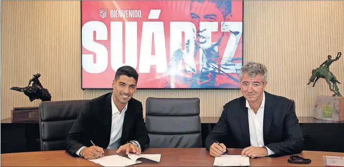  ??  ?? Luis Suárez y el consejero delegado, Miguel Ángel Gil, firman el contrato que vincula al jugador con el Atlético hasta 2022.