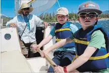  ?? RACHEL WALKER FOR THE WASHINGTON POST ?? Thomas Emrick, left, instructs Silas Walker and his brother Henry how to steer a sailboat during a lesson on Lake Dillon in Colorado.