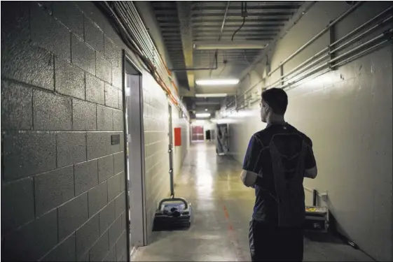  ??  ?? 51s relief pitcher Paul Sewald walks through a hallway outside the clubhouse before a game against El Paso on May 13. Below, Sewald does stretching exercises and talks with strength and conditioni­ng coach Jon Cioffi, left, and Nevin Ashley.