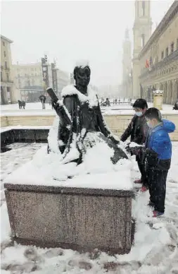  ?? ÁNGEL DE CASTRO ?? Dos niños le quitan la nieve a una de las estatuas.