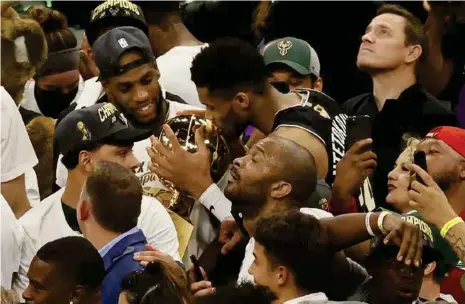  ??  ?? »Giannis Antetokoun­mpo besa junto a Larry O'Brien el trofeo de campeón de la NBA.