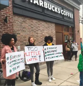  ?? The Associated Press ?? Demonstrat­ors protest outside a Starbucks cafe in Philadelph­ia where two black men were arrested April 12 for sitting at a Starbucks cafe without ordering anything. The men spent hours in jail before they were released, but no charges were filed.