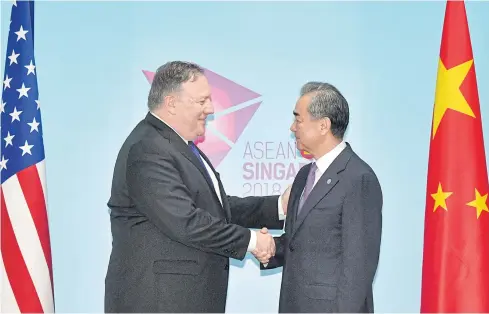  ?? AP ?? US Secretary of State Mike Pompeo, left, and China’s Foreign Minister Wang Yi shake hands ahead of a bilateral meeting on the sidelines of the Asean Foreign Ministers Meeting in Singapore on Friday.
