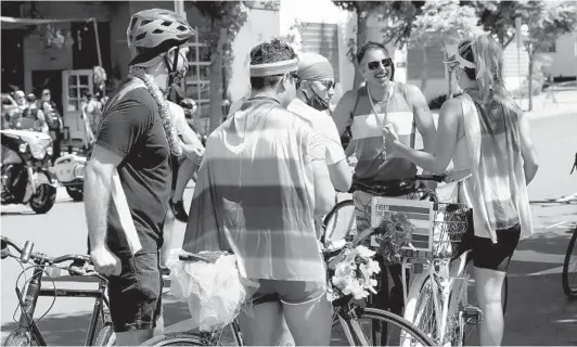  ?? NELVIN C. CEPEDA U-T PHOTOS ?? A group of bicyclists gathers Saturday near the flag at University Avenue and Normal Street to ride down what would have been the traditiona­l San Diego Pride parade route. This year, much of the celebratio­n and entertainm­ent took place in a livestream broadcast.