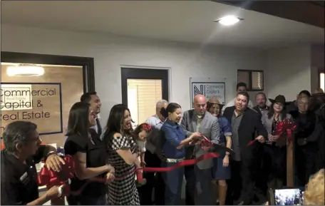  ?? COURTESY PHOTO ?? Nava Commercial Capital Real Estate owner George Nava (holding scissors) cuts the ribbon for the grand opening of his offices.