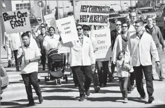  ?? Herald photo by Ian Martens @IMartensHe­rald ?? Pharmacist­s and supporters march from Galt Gardens to MLA Shannon Phillips office Thursday to protest what they see as cuts to frontline pharmacy services by the NDP government.