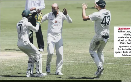  ??  ?? CENTURION Nathan Lyon, middle, celebrates a wicket on his 100th Test appearance for Australia against India at Brisbane